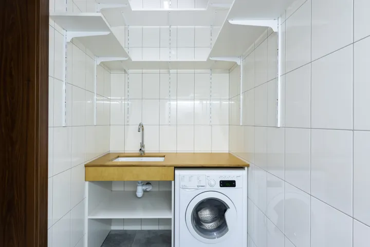 Washing machine in a bright tiled laundry space